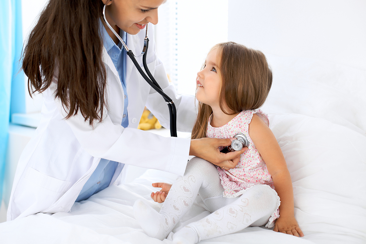 Doctor examining a little girl by stethoscope