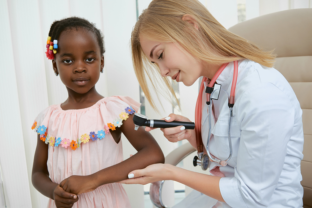 Image of a doctor treating a female child.